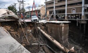 At a central junction, in front of a local police station and Vajira Hospital in a residential district of Bangkok, a roughly 50-metre (160-foot) hole pulled down power lines and revealed a burst pipe gushing water. Dozens of police and city officials blocked off the site to prevent more damage and fatalities, when this happened a pickup truck teetered precariously on the edge of the hole. Suriyachai Rawiwan, director of Bangkok’s disaster prevention department, present at the scene reported that the collapse was likely linked to recent heavy rain and a leaky pipe.